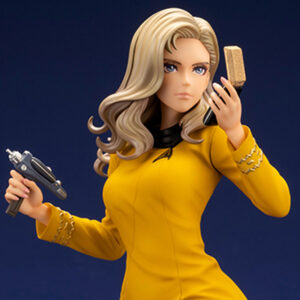 Bishoujo statue of a Star Trek: The Original Series Command Officer, depicted in a dynamic pose holding a phaser and communicator. The character wears a yellow command uniform dress, black boots, and stands on a rocky base. The figure features a stylized design with long flowing blonde hair, capturing the essence of the iconic science fiction series.